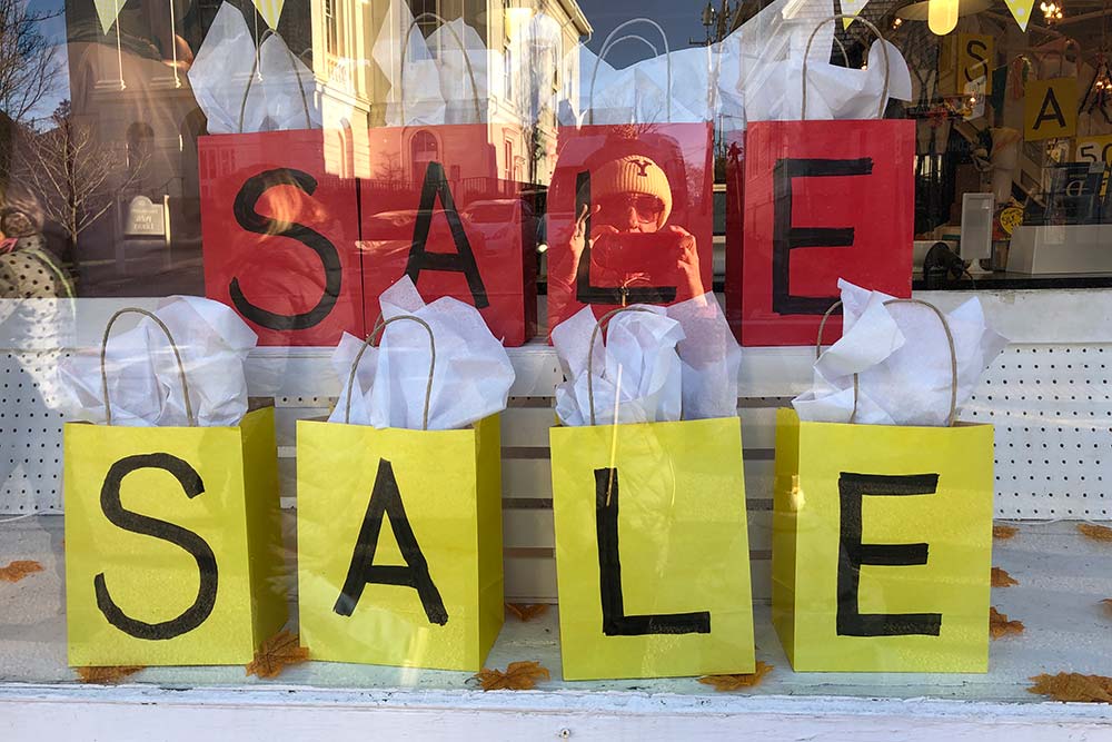 Consumer law - goods for sale in a shop window with colourful sale signs