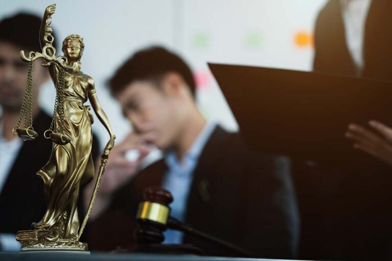 Lawyers in the office, with lady justice in front